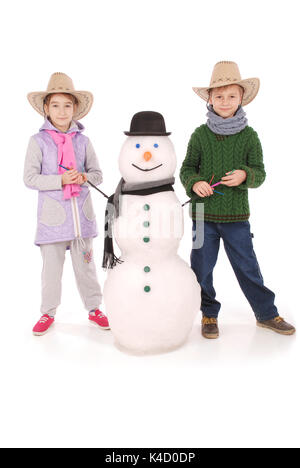 Cute boy and girl with snowman with scarf and hat on white background Stock Photo