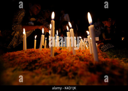 Family members light candles and put them on the graves of their loved ones during All Souls' Day on November 02 at Holy Rosary Catholic Church in Dha Stock Photo