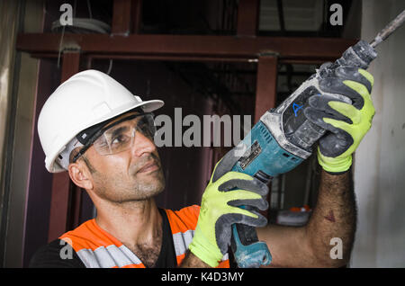 Construction worker working with hammer drill Stock Photo