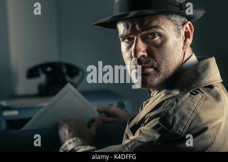 Vintage undercover spy stealing files in a filing cabinet late at night, security, data theft and crime concept Stock Photo