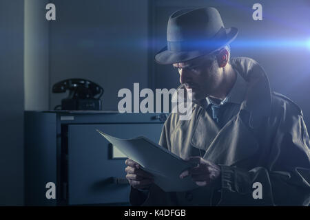 Vintage undercover agent stealing files in a corporate office late at night, security and data theft concept Stock Photo