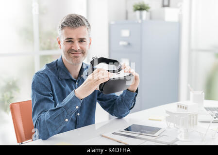 Professional architect working at office desk and holding a virtual reality headset, technology and innovation concept Stock Photo
