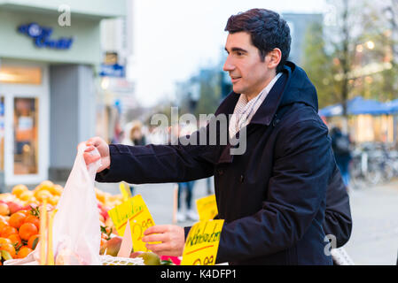 Man buying groceries on farmers market stand Stock Photo