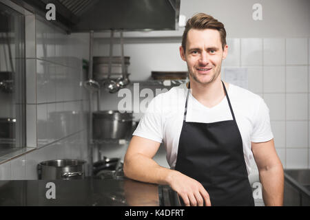 Front portrait of confident handsome chef standing in the kitchen Stock Photo
