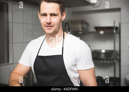 Front portrait of male chef standing in kitchen Stock Photo