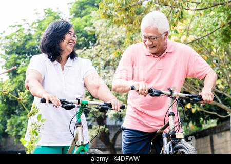Portrait of active senior couple standing on bicycles Stock Photo