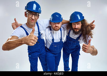Three funny young builders - isolated portrait Stock Photo