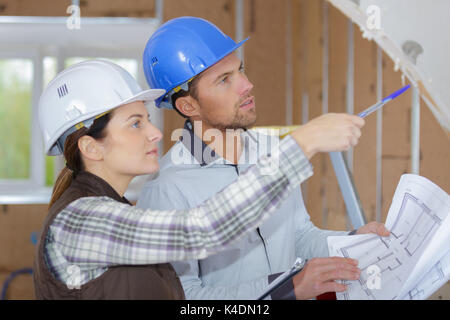 two young architects discuss about construction plan Stock Photo
