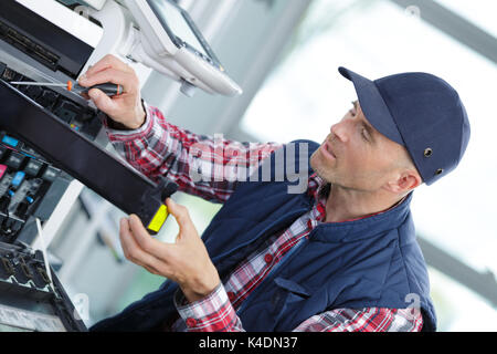 man fixing copier in the office Stock Photo