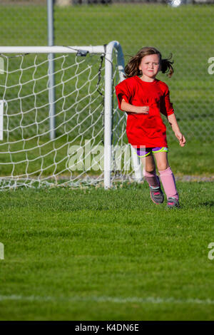 Five year old girl running on a soccer field Stock Photo