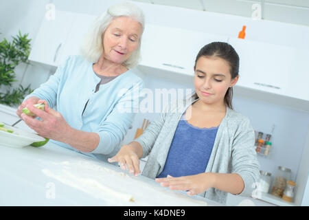 senior nanny cooking with child Stock Photo