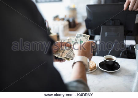 Customer paying with cash at cafe counter