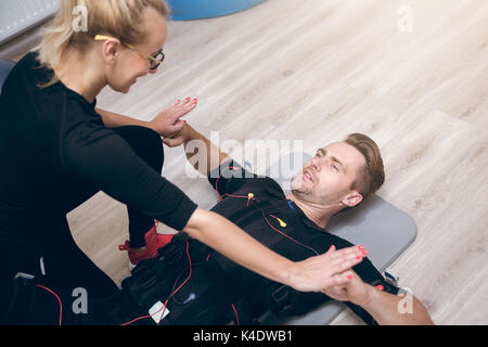 Aerial portrait of sportsman lying on floor training with coach Stock Photo