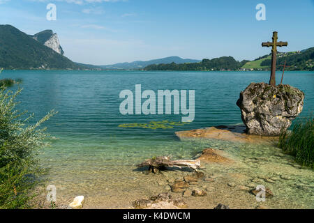 Kreuzstein im Mondsee, Salzkammergut,  Österreich  |  Cross on a rock, lake Mondsee, Salzkammergut region, Austria Stock Photo