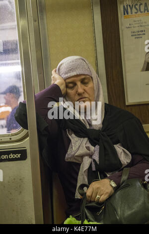 Tired woman riding a subway train in Manhattan at rush hour, NYC. Stock Photo