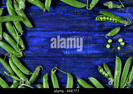 green peas on a blue wooden background. background in rustic style. bright green colors and blue. Vegetables Stock Photo