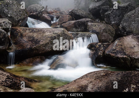 Foggy day near waterfall of Studeny potok stream in the National Park High Tatra, Slovakia Stock Photo