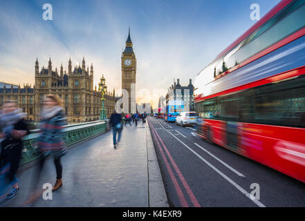 London, England - The iconic Big Ben and the Houses of Parliament with famous red double-decker bus and tourists on the move on Westminster bridge at  Stock Photo