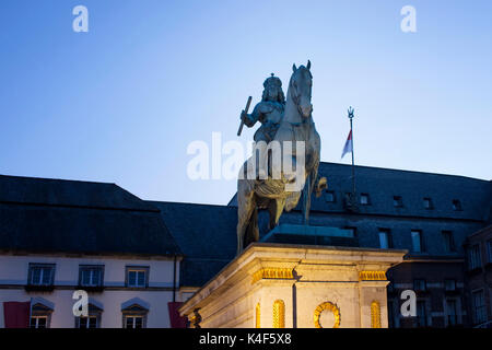 Close up view of a sculpture (Jan Wellem Reiterstandbild) in blue hour in Dusseldorf. Old, historical buildings are in background. Stock Photo