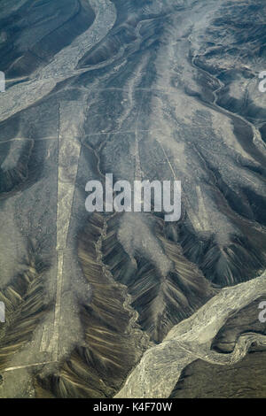 Palpa Lines (ancient geoglyphs) and dry riverbed in the desert near Nazca, Ica Region, Peru, South America - aerial Stock Photo