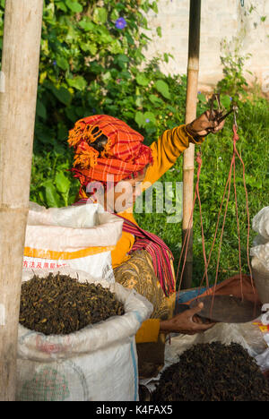 Burmese woman weighing dried tea leaves on scale in a market in Kalaw, Shan State, Myanmar, Burma, South East Asia Stock Photo