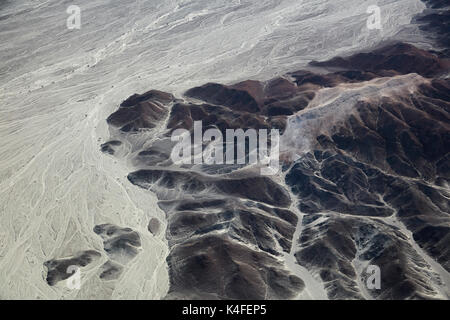Dry waterways and barren mountains at Nazca Lines, Ica Region, Peru, South America - aerial Stock Photo