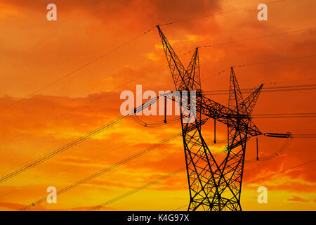 Electrical pylon and high power lines against a dramatic sunset Stock Photo