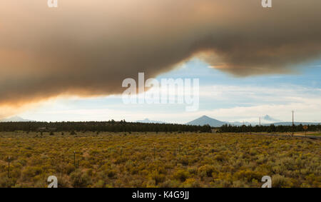 Smoke from Oregon wildfires rises up in the sky at sunset Stock Photo