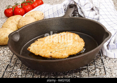 freshly baked potato pancake in a cast iron pan Stock Photo
