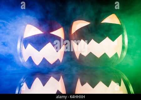Two glowing pumpkins for Halloween with color lights Stock Photo