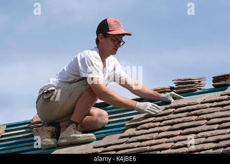 Roofer fixing tiles onto a new roof Stock Photo