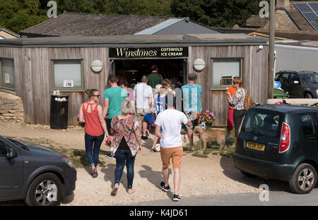Customers queuing for ice cream outside Winstones shop on Rodborough Common in the southern Cotswolds, Gloucestershire England UK Stock Photo