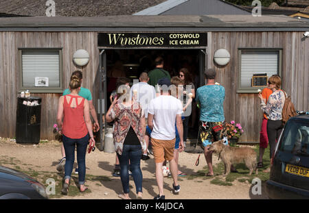 Customers queuing for ice cream outside Winstones shop on Rodborough Common in the southern Cotswolds, Gloucestershire England UK Stock Photo