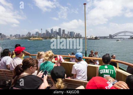 Tourists on the Manly ferry as it approaches Circular Quay, the Opera House and Sydney Harbour Bridge, NSW,New South Wales, Australia Stock Photo