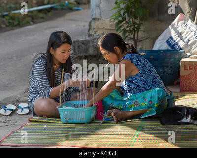Teenage girl with a woman making craft products, Chiang Rai, Thailand Stock Photo