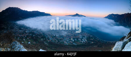 Panoramic of fog at sunrise above the city of Lecco seen from Monte San Martino, Province of Lecco, Lombardy, Italy, Europe Stock Photo