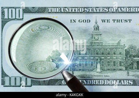 100 US Dollar under magnifying glass Stock Photo