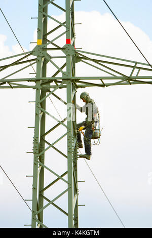 Painter on high-voltage mast, Winnenden, Baden-Wuerttemberg, Germany Stock Photo