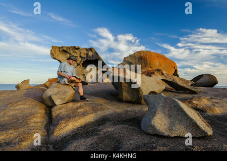 Person sitting on a rock seat at Remarkable Rocks.