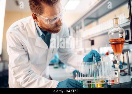 Handsome student of chemistry working in laboratory Stock Photo
