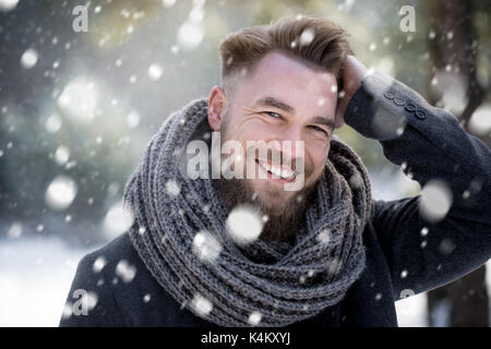 Smiling man in snowing forest Stock Photo