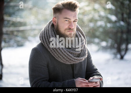 Serious man texting on a biting frost Stock Photo
