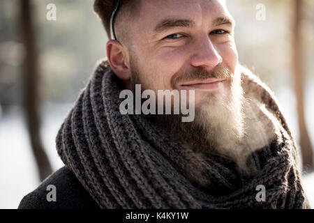 Cheerful handsome man walking in winter forest Stock Photo