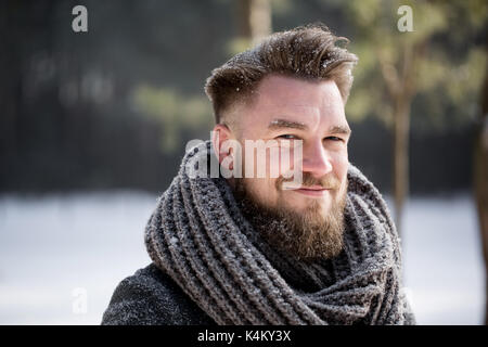 Portrait of a smiling man wearing winter coat in white forest Stock Photo