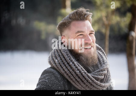 Handsome man smiling in winter woods Stock Photo