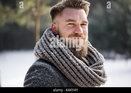 Young man in winter clothes on a winter walk in forest Stock Photo