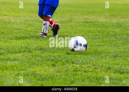 Football player running for a ball Stock Photo