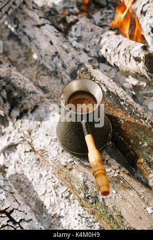 Making coffee in the fireplace  on camping or hiking in the nature Stock Photo