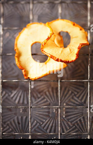 Dried apple slices hanging on string with dark metal backdrop Stock Photo