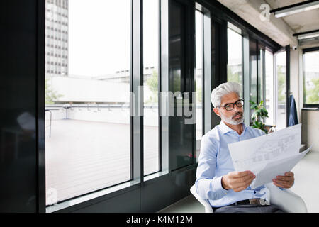 Mature businessman in blue shirt in the office. Stock Photo